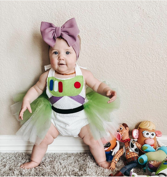 Baby in Buzz Lightyear costume with toys on a carpeted floor