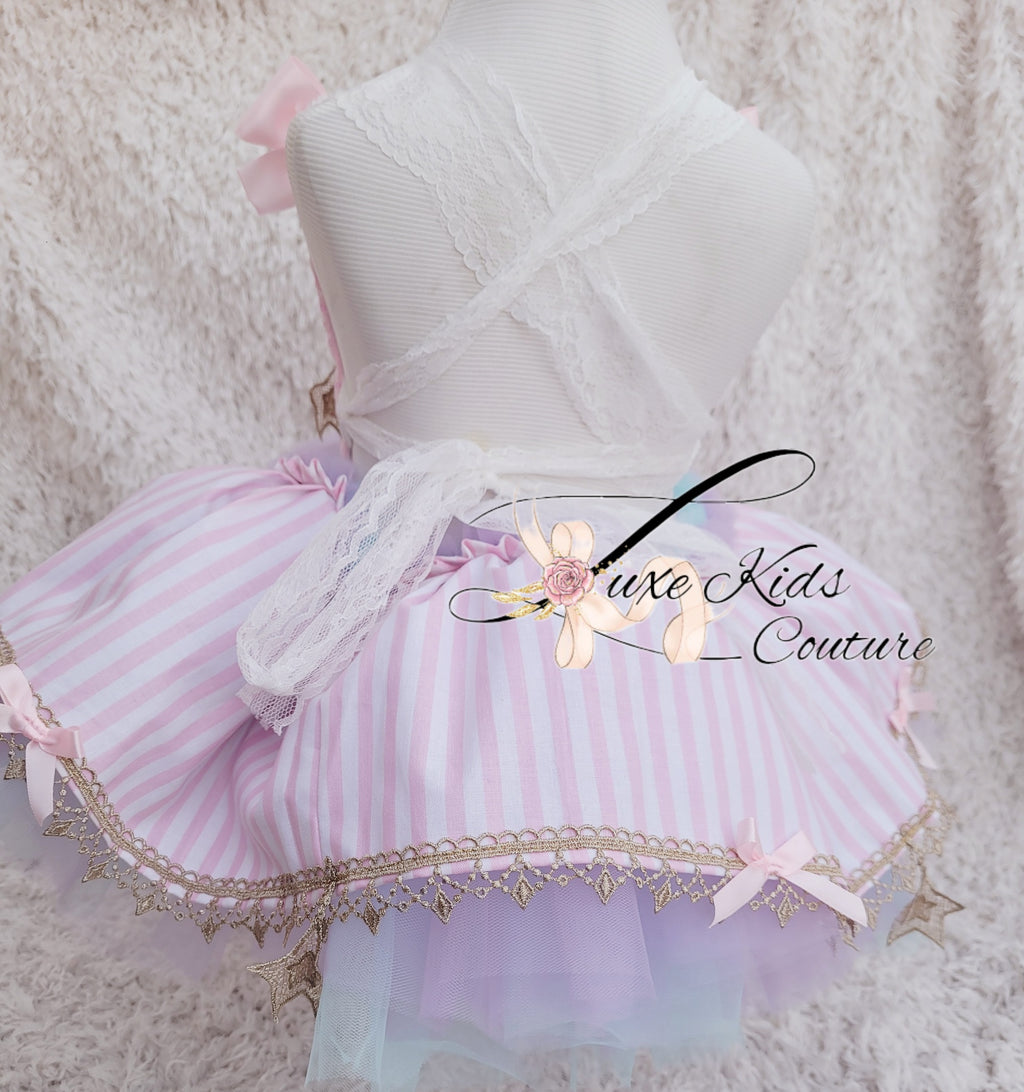 Children's dress with pink and white striped skirt on a soft textured background, featuring 'Luxe Kids Couture' branding.